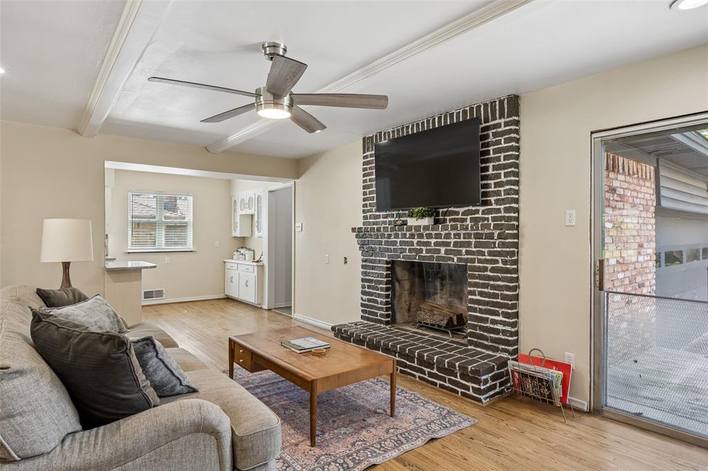8049 Woodhue Road Dallas, TX 75228 - Photo 5 of 24 a living room with furniture a flat screen tv and a fireplace