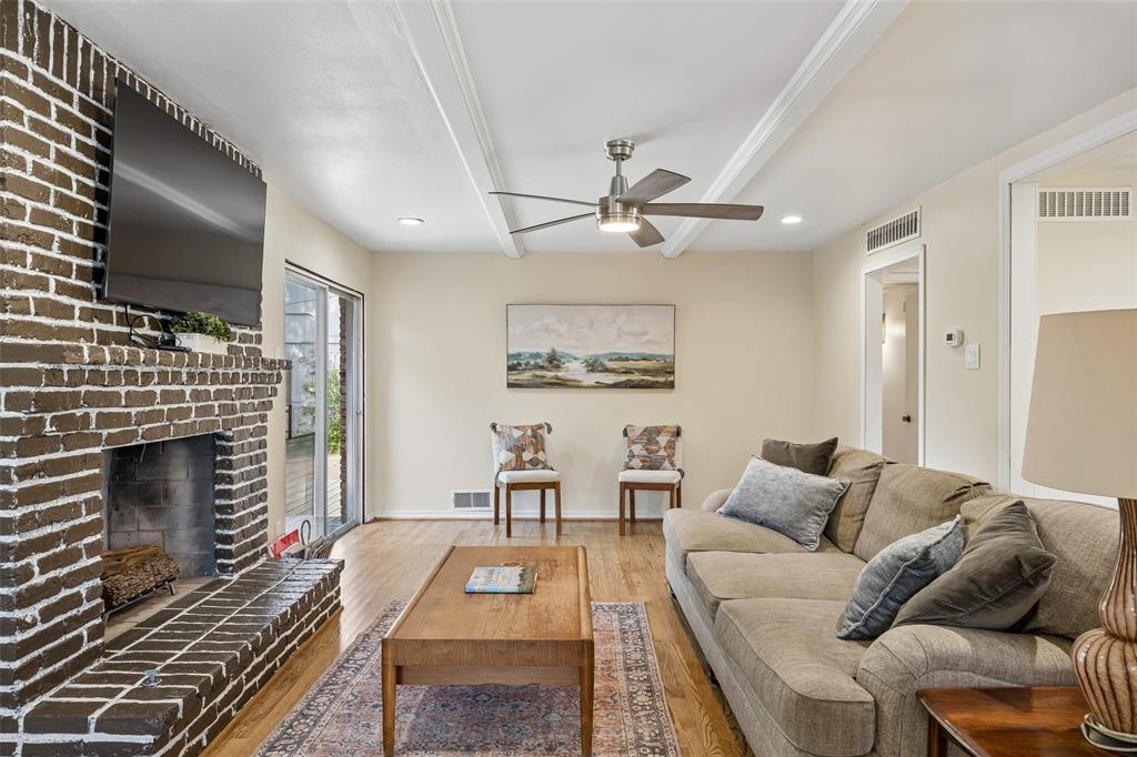 8049 Woodhue Road Dallas, TX 75228 - Photo 6 of 24 a living room with furniture a flat screen tv and a fireplace