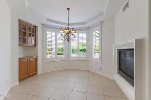 a view of an empty room with a fireplace and a window