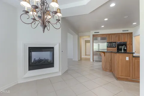 a view of an empty room with a fireplace and windows