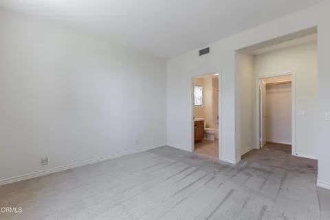 a view of an empty room with closet and a window