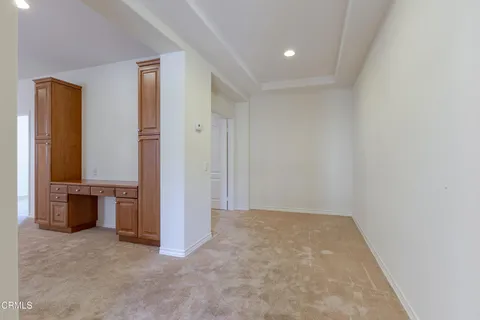 a spacious bedroom with a bed a mirror and a flat screen tv
