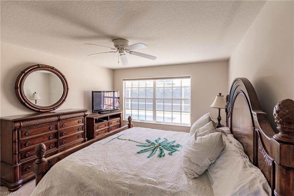 4113 Tabago Lane Naples, FL 34119 - Photo 21 of 50 Bedroom featuring a textured ceiling and ceiling fan