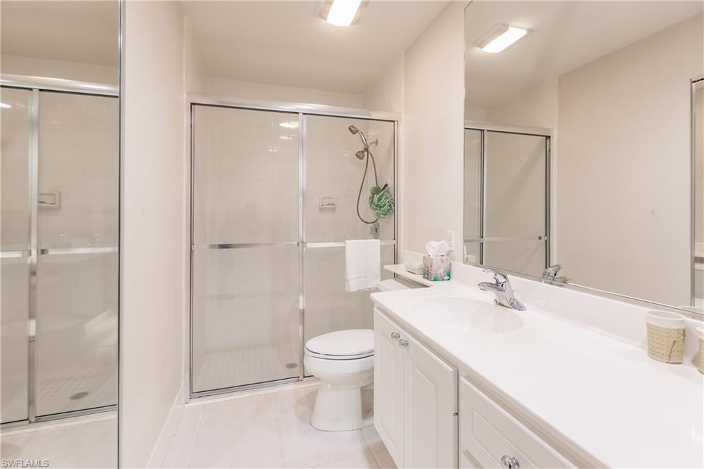 4113 Tabago Lane Naples, FL 34119 - Photo 23 of 50 Bathroom featuring tile patterned floors, vanity, toilet, and walk in shower