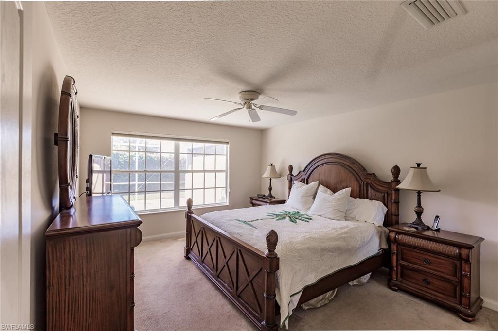 4113 Tabago Lane Naples, FL 34119 - Photo 27 of 50 Carpeted bedroom featuring ceiling fan and a textured ceiling