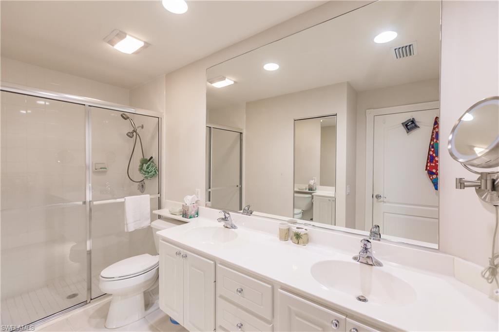 4113 Tabago Lane Naples, FL 34119 - Photo 30 of 50 Bathroom featuring tile patterned floors, vanity, toilet, and an enclosed shower