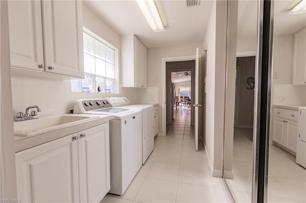 4113 Tabago Lane Naples, FL 34119 - Photo 37 of 50 Washroom featuring cabinets, sink, ceiling fan, washing machine and dryer, and light tile patterned flooring