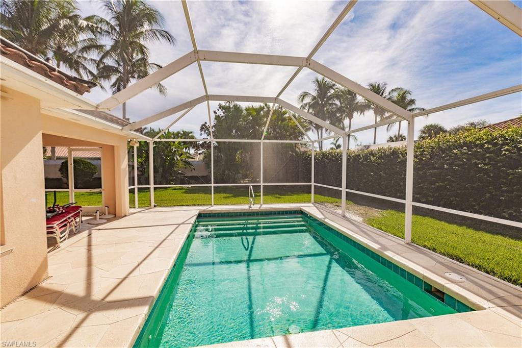 4113 Tabago Lane Naples, FL 34119 - Photo 4 of 50 View of swimming pool featuring glass enclosure, a yard, and a patio