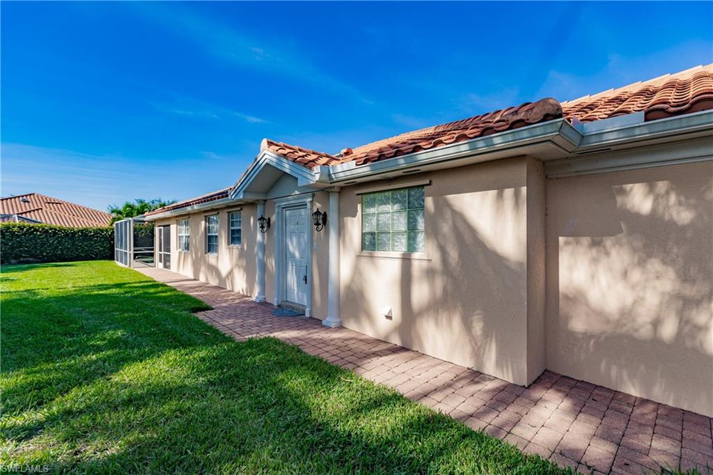 4113 Tabago Lane Naples, FL 34119 - Photo 5 of 50 View of property exterior featuring a yard