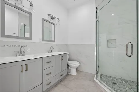 a bathroom with a double vanity sink toilet and shower