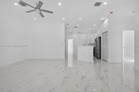 an empty room with closet and a ceiling fan