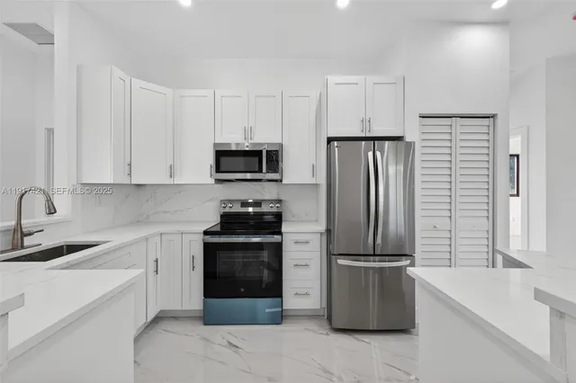 a kitchen with a refrigerator stove and white cabinets