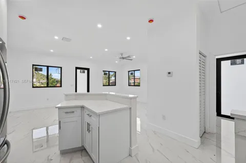 a view of cabinets a sink wooden floor and a window