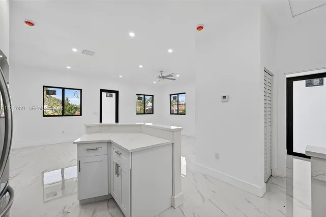 a view of cabinets a sink wooden floor and a window