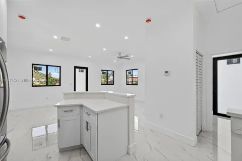 a view of cabinets a sink wooden floor and a window