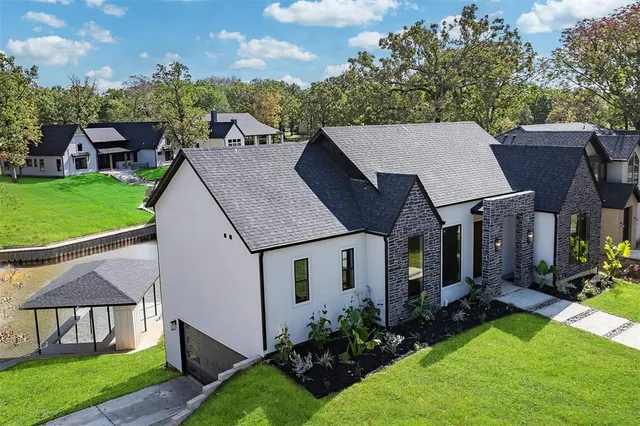 a aerial view of a house next to a big yard and large trees