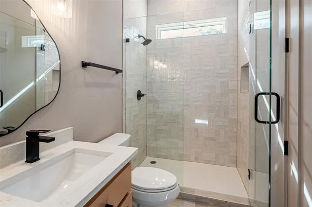 a bathroom with a sink a toilet and shower