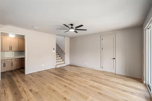 a view of a livingroom with a ceiling fan wooden floor and a ceiling fan