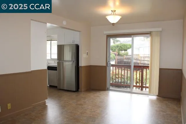 a view of kitchen with refrigerator and wooden floor