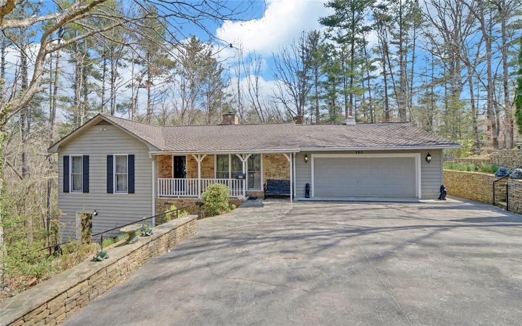 a front view of a house with a garden and trees