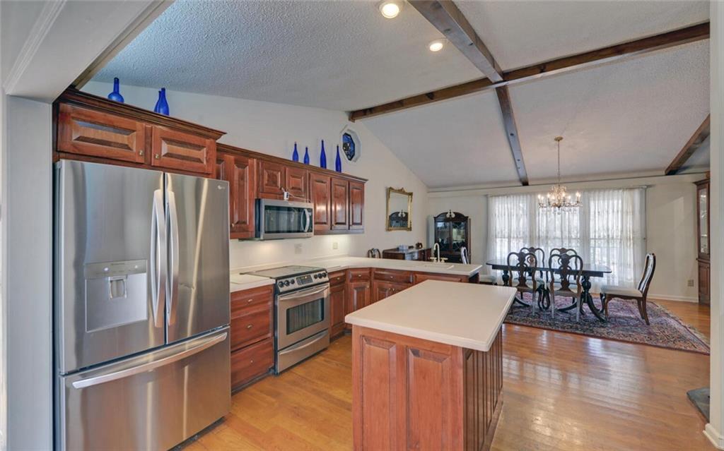 290 Waterfall Drive Cleveland, GA 30528 - Photo 20 of 46 a kitchen with stainless steel appliances granite countertop a refrigerator a sink dishwasher a stove and a dining table with wooden floor