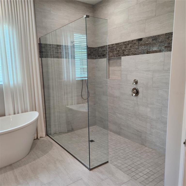 512 Blue Shell Loop Sarasota, FL 34240 - Photo 24 of 44 a bathroom with a bathtub and a shower