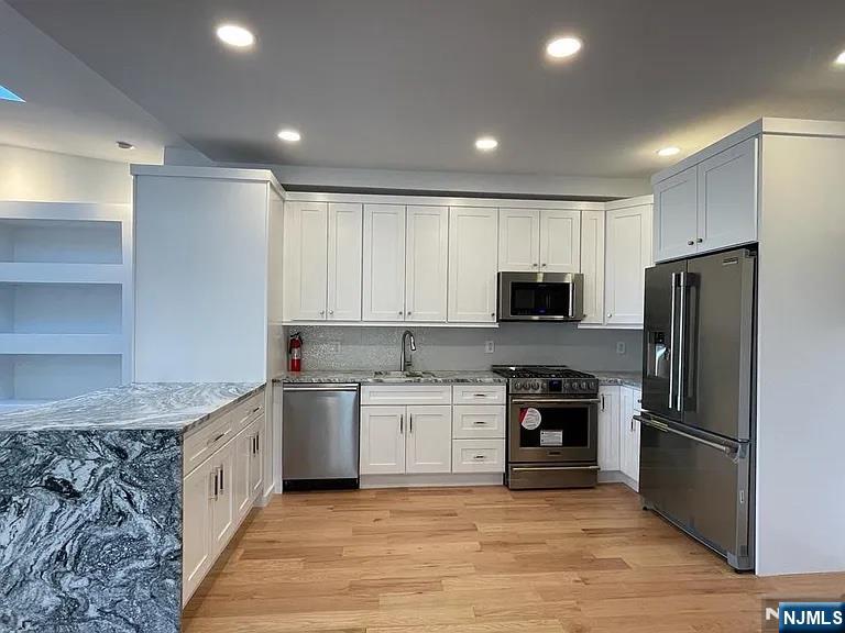 9009 Riverside Place, Unit 2 North Bergen, NJ 07047 - Photo 3 of 14 a large kitchen with a stove top oven a refrigerator and a sink