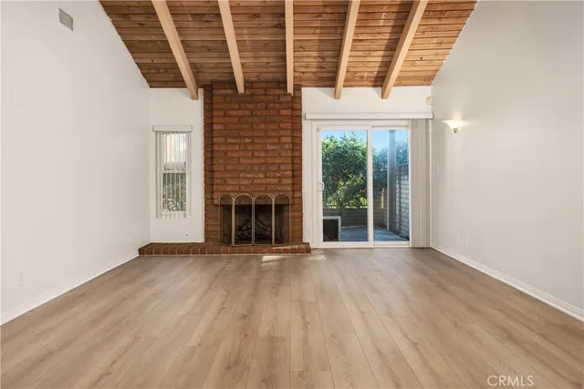an empty room with wooden floor and a window
