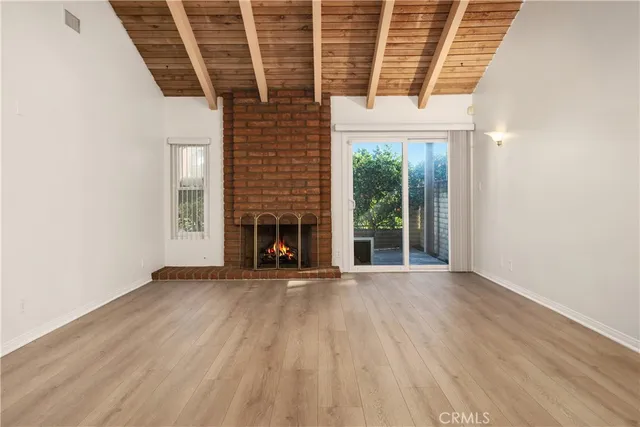 an empty room with wooden floor and fireplace