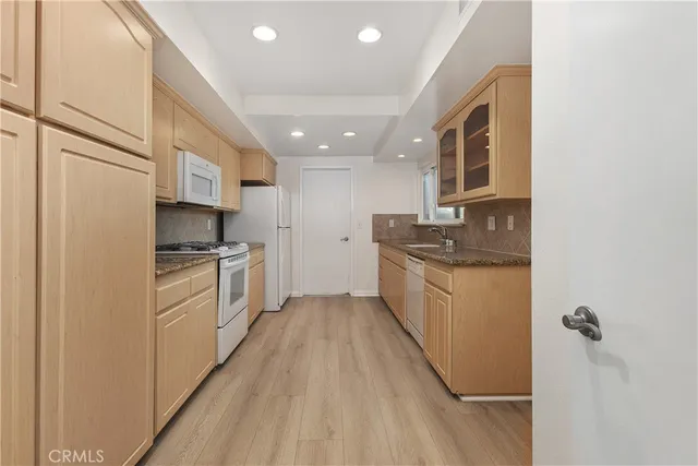 a kitchen with granite countertop a sink stove and refrigerator