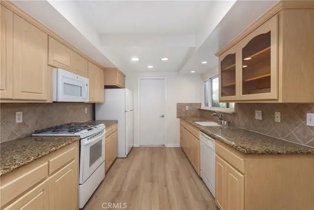 a kitchen with a sink stove top oven and cabinets