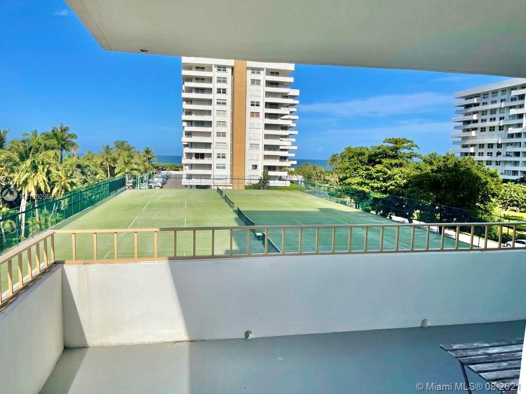 a view of a balcony with a floor to ceiling window and potted plants