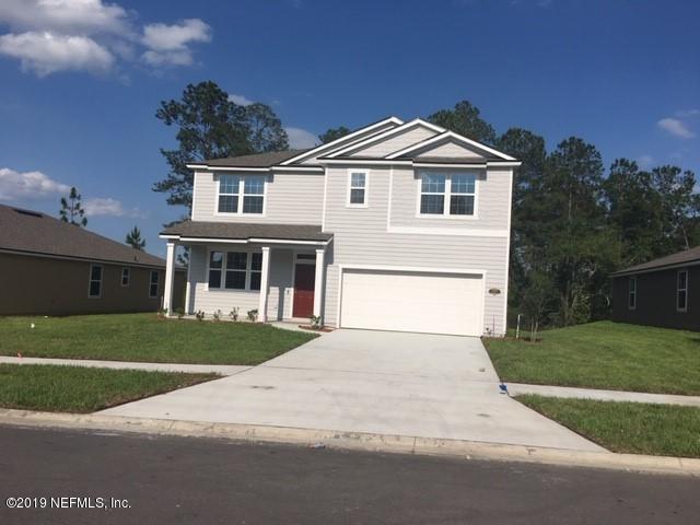a front view of a house with a garden and yard