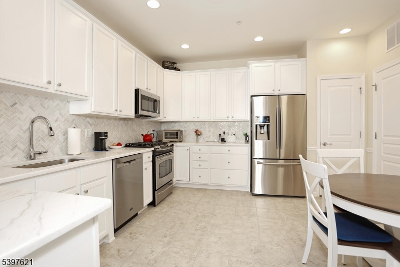 3214 Warren's Way Wanaque, NJ 07465 - Photo 14 of 42 a kitchen with a refrigerator a white stove top oven and white cabinets