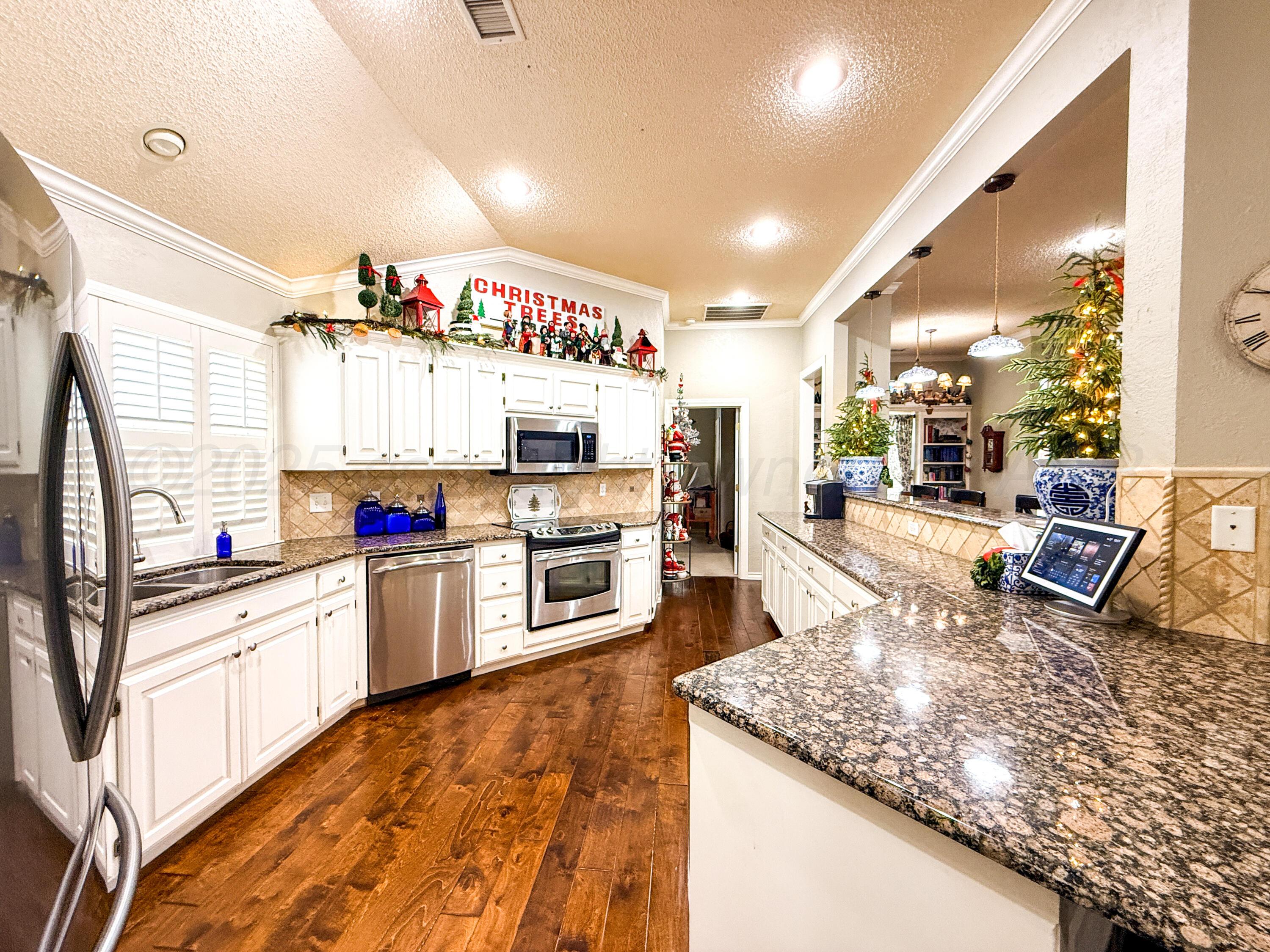 5724 Spencer Street Amarillo, TX 79109 - Photo 11 of 37 a kitchen with stainless steel appliances granite countertop a sink stove and refrigerator