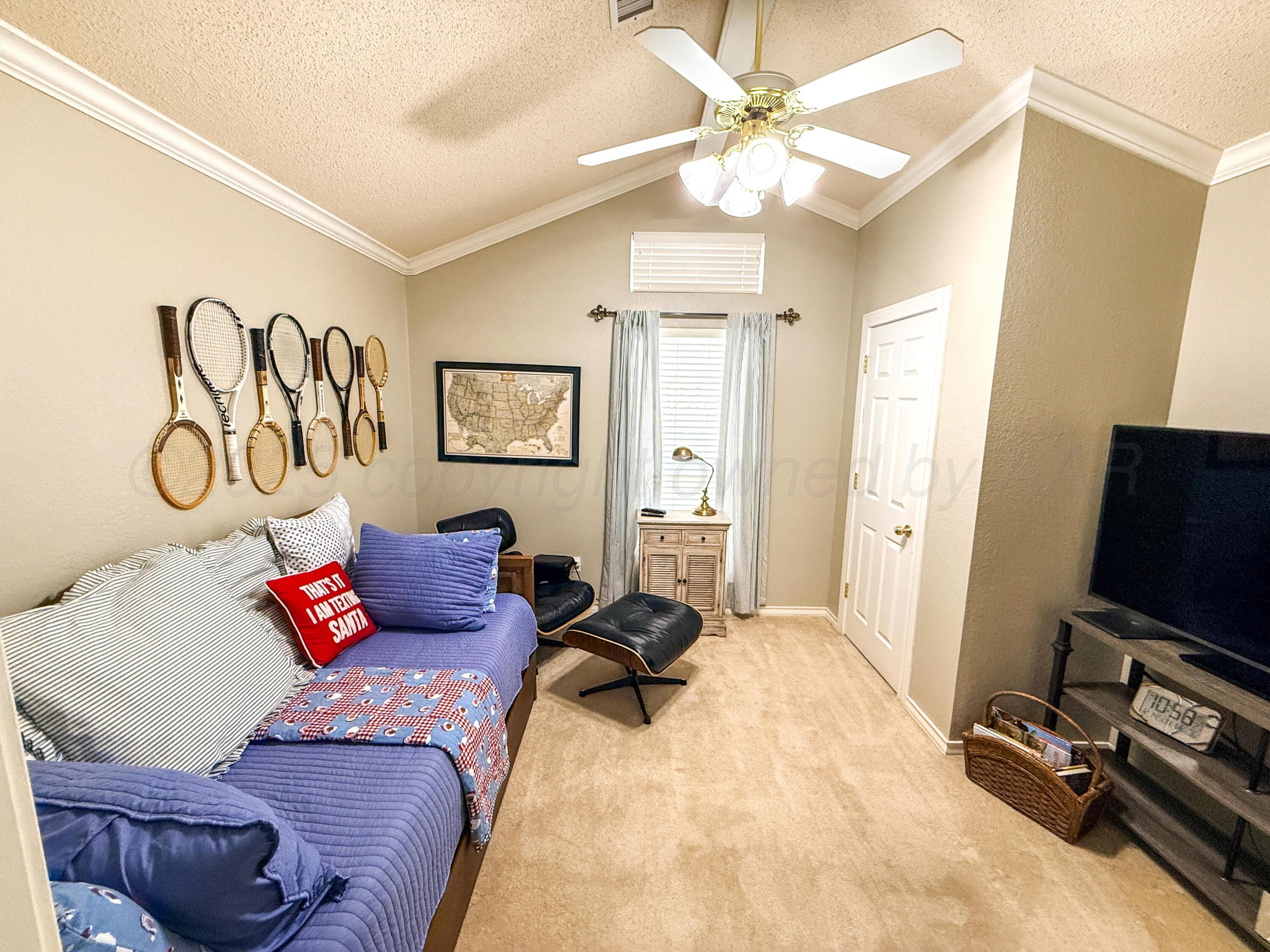 5724 Spencer Street Amarillo, TX 79109 - Photo 17 of 37 a bedroom with furniture and a flat screen tv
