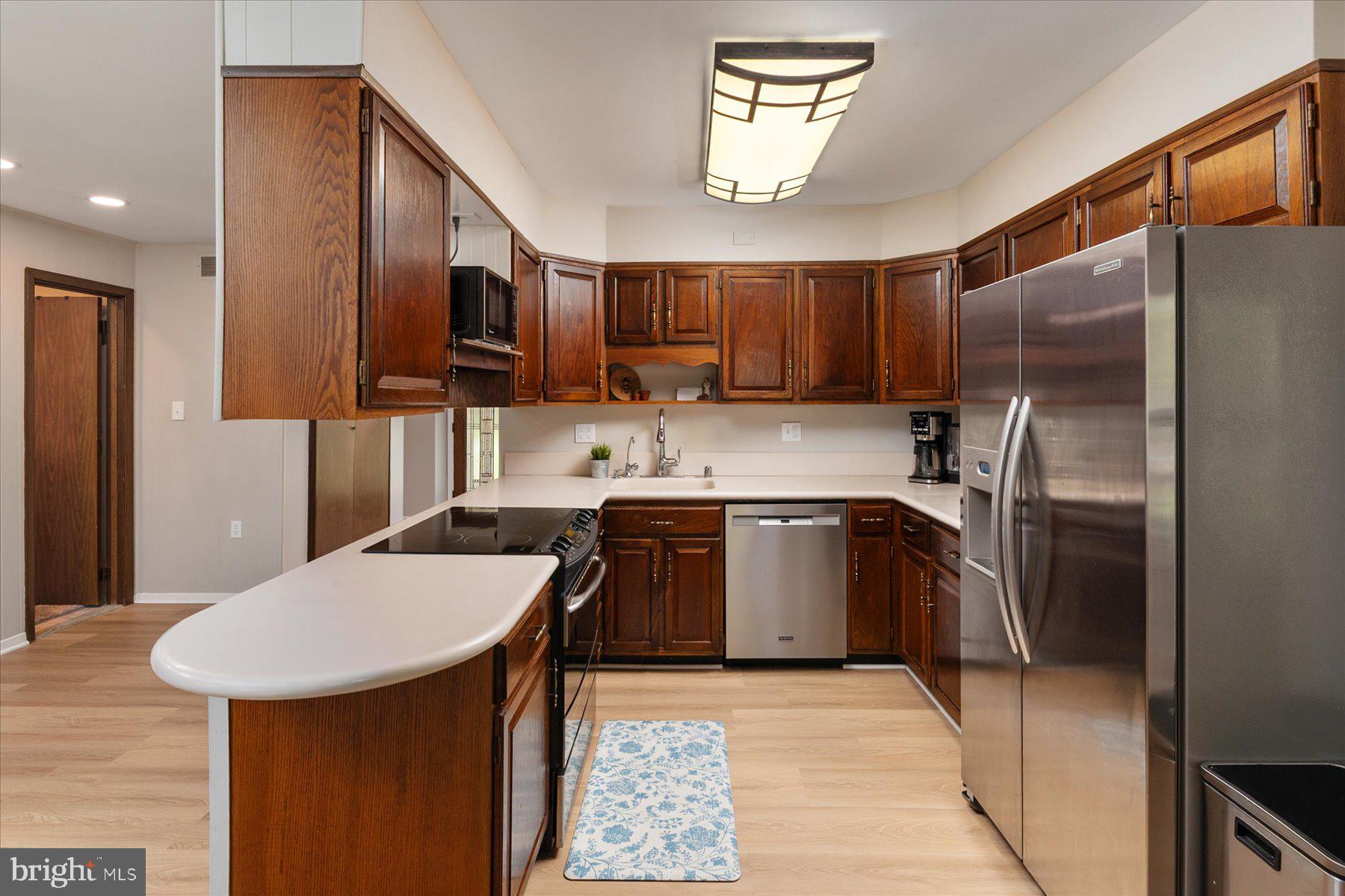 86 Milburn Circle Pasadena, MD 21122 - Photo 13 of 60 a kitchen with stainless steel appliances granite countertop a sink refrigerator and microwave