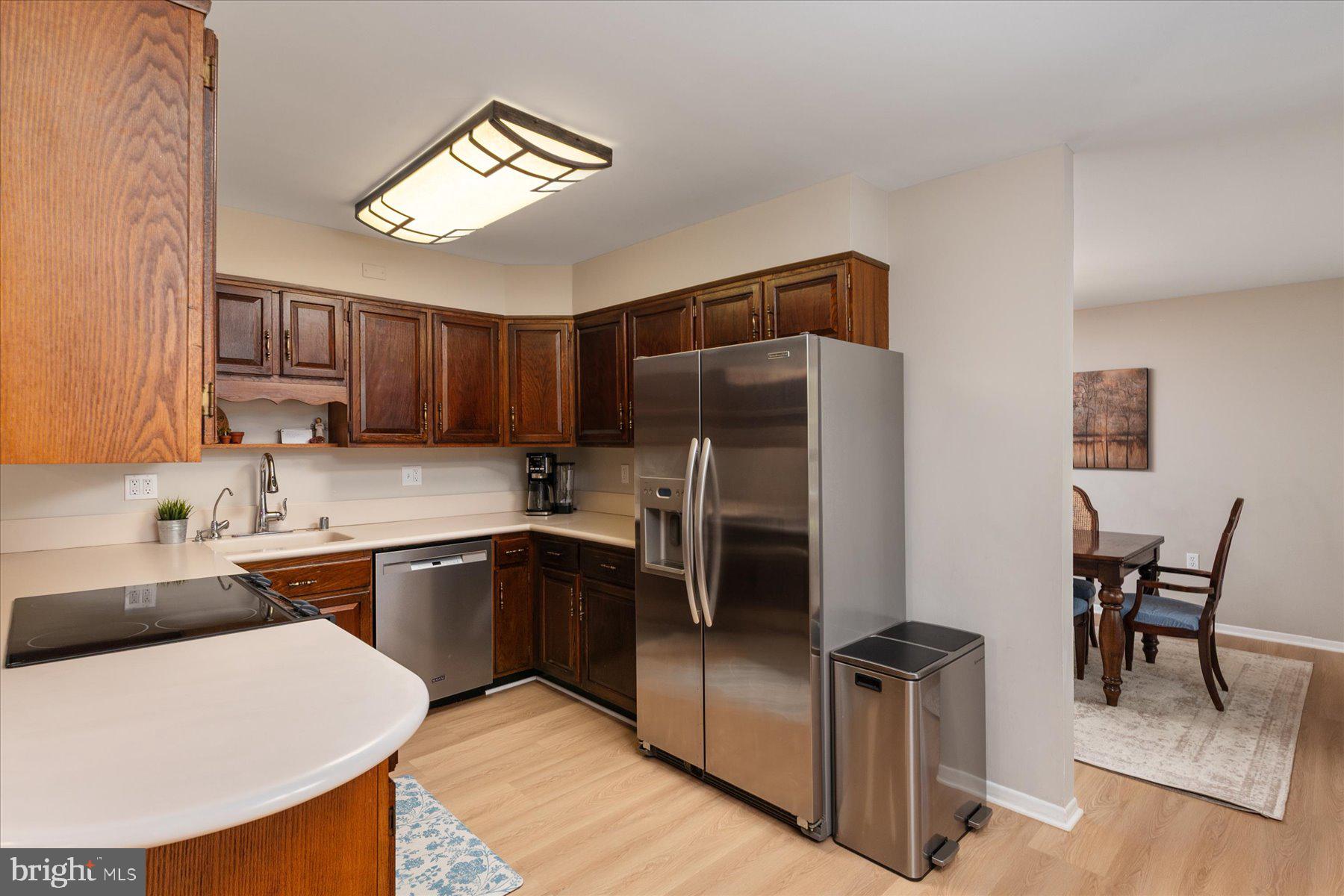86 Milburn Circle Pasadena, MD 21122 - Photo 14 of 60 a kitchen with stainless steel appliances granite countertop a sink a stove a refrigerator cabinets and chairs