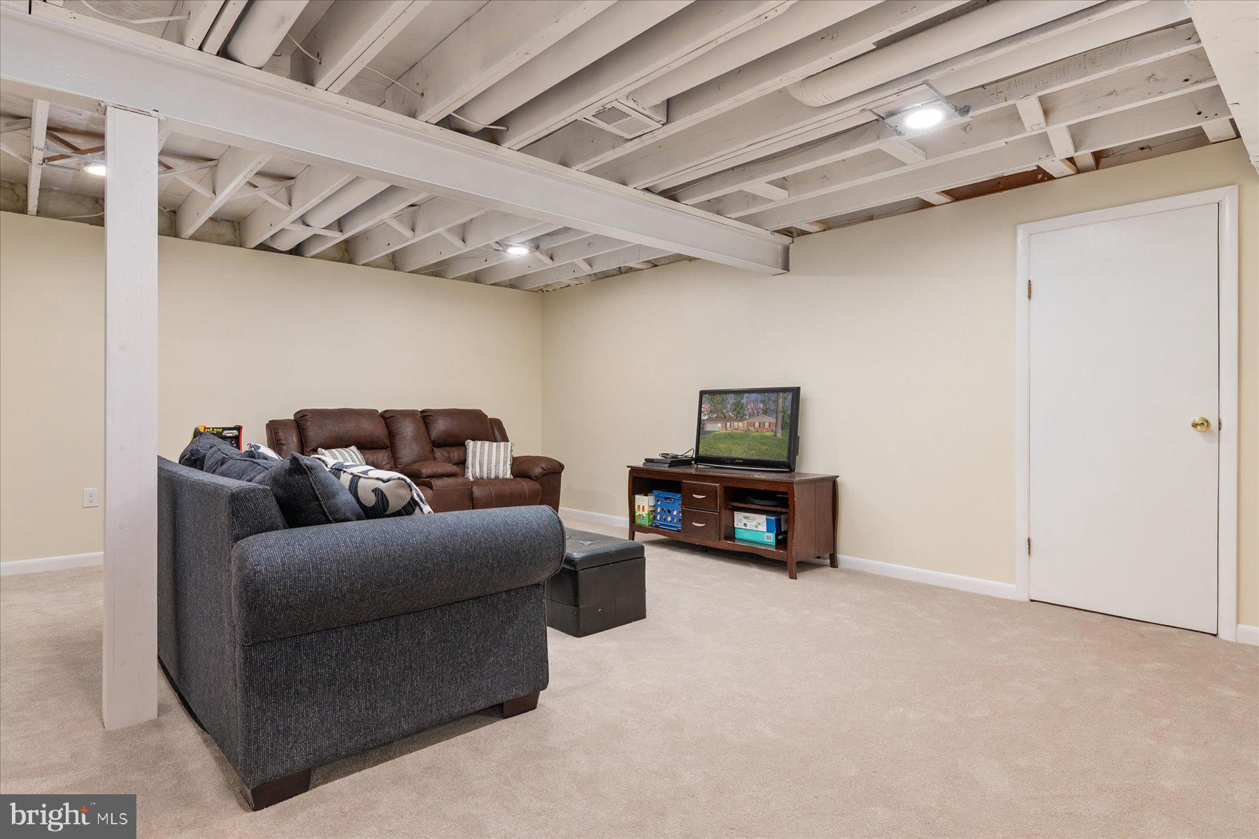 86 Milburn Circle Pasadena, MD 21122 - Photo 41 of 60 a living room with furniture a flat screen tv and a ceiling fan