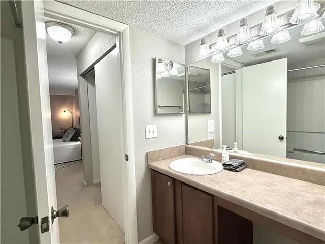 a bathroom with a granite countertop sink and a mirror
