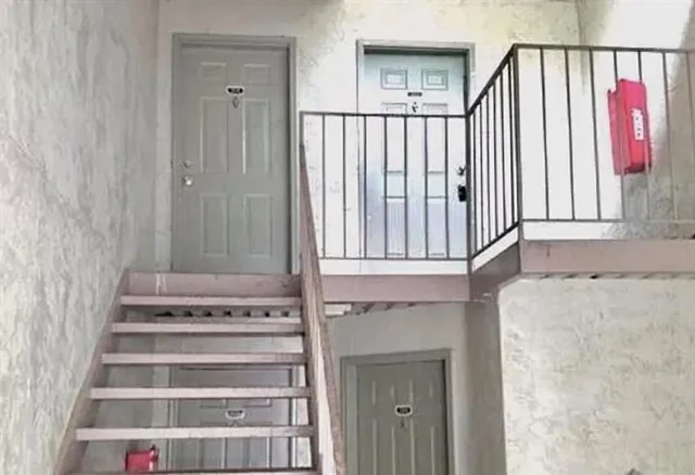 a view of staircase with railing and white walls