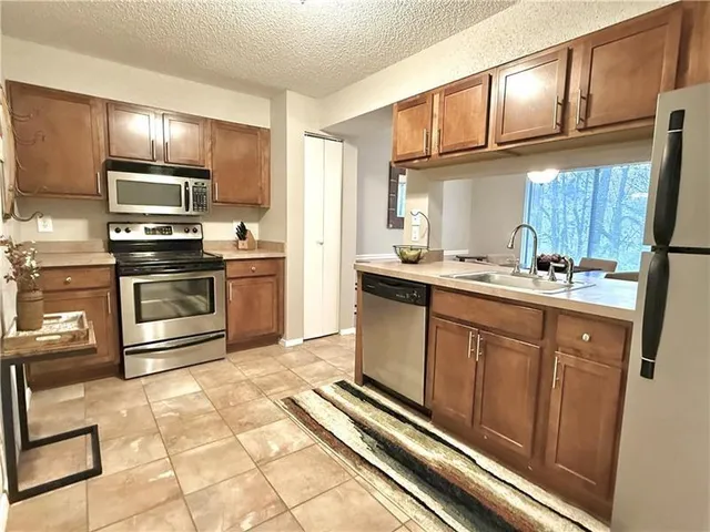 a kitchen with stainless steel appliances a sink stove and cabinets