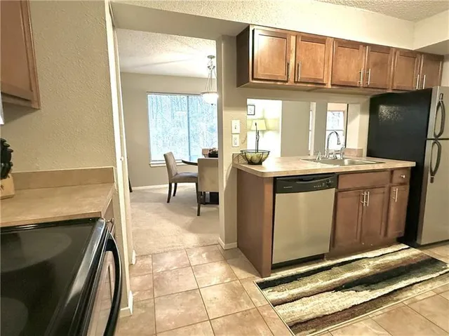 a kitchen with stainless steel appliances granite countertop a sink stove and cabinets