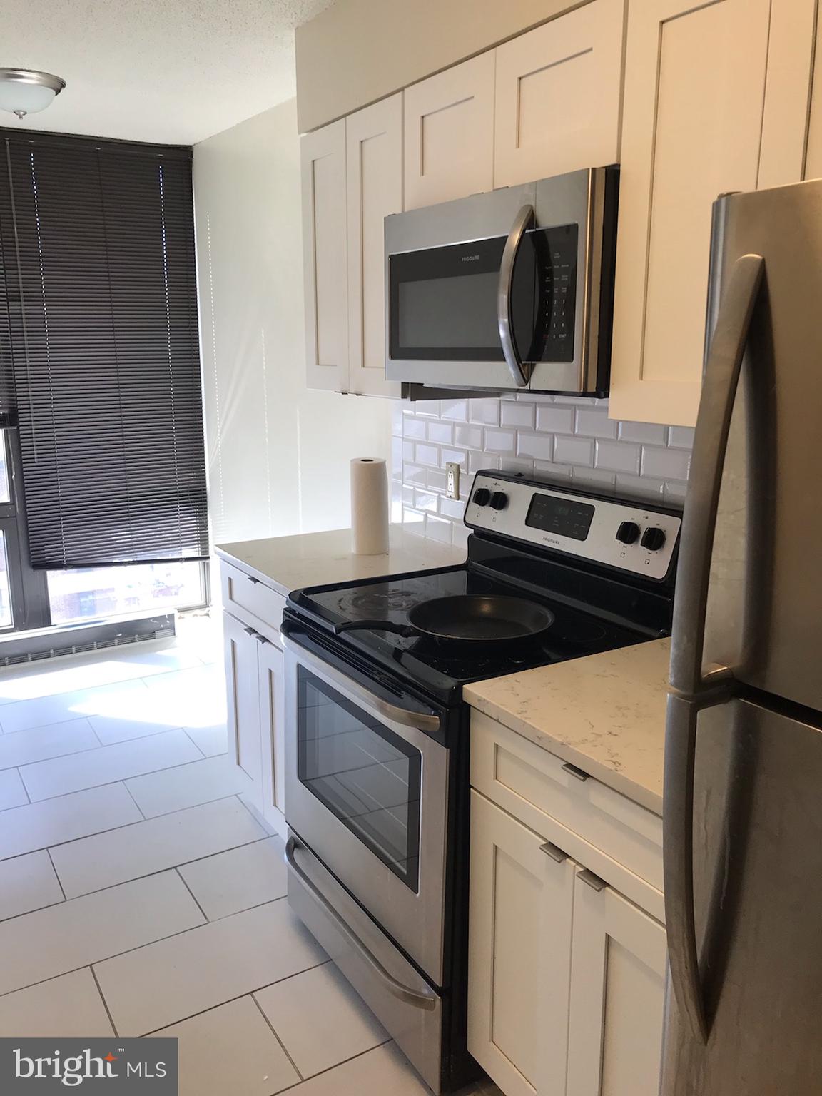 2020 Walnut Street, Unit 21E Philadelphia, PA 19103 - Photo 5 of 19 a kitchen with a stove and a microwave