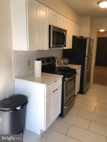 a kitchen with stainless steel appliances a stove microwave and refrigerator