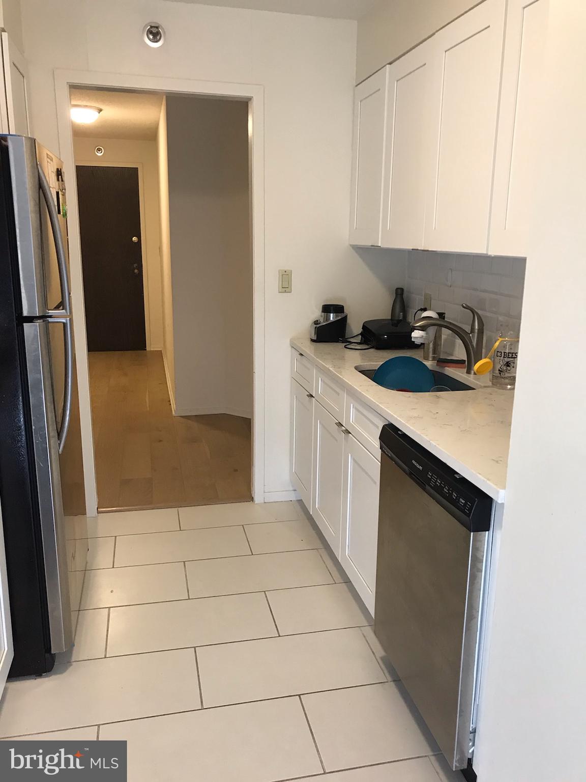 2020 Walnut Street, Unit 21E Philadelphia, PA 19103 - Photo 7 of 19 a kitchen with a sink a refrigerator and cabinets