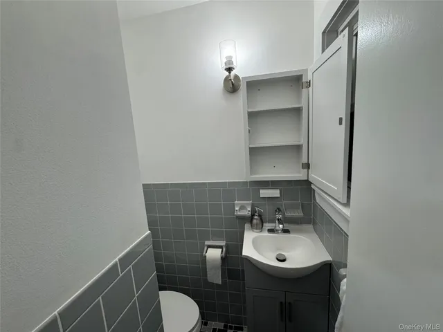 a bathroom with a sink toilet and a mirror