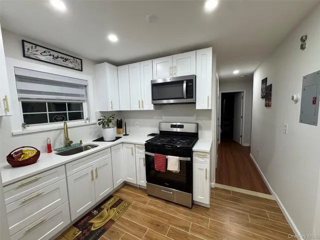 a kitchen with stainless steel appliances a stove sink microwave and cabinets