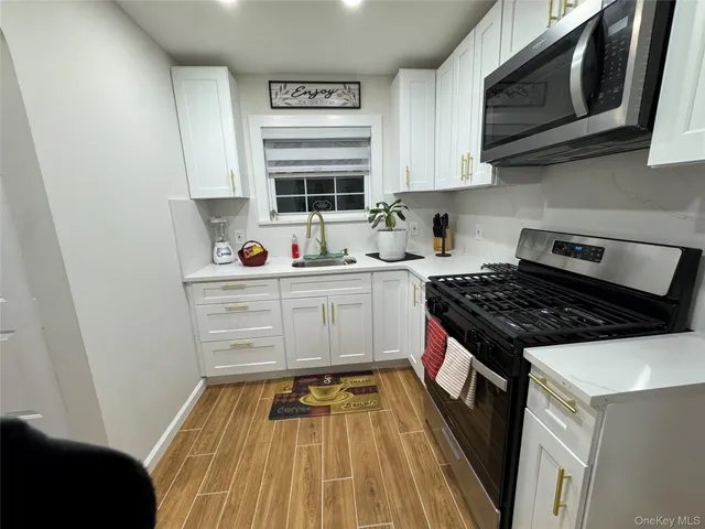 a kitchen with stainless steel appliances a sink stove top oven and cabinets