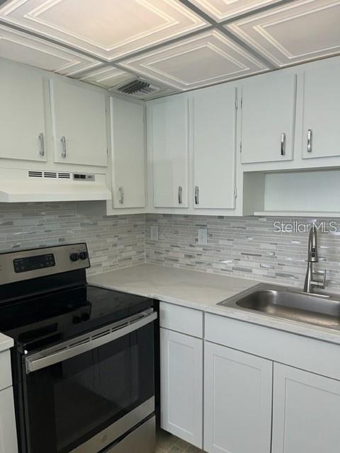 3300 Fox Chase Circle, Unit 226 Palm Harbor, FL 34683 - Photo 3 of 13 a kitchen with granite countertop white cabinets and stainless steel appliances